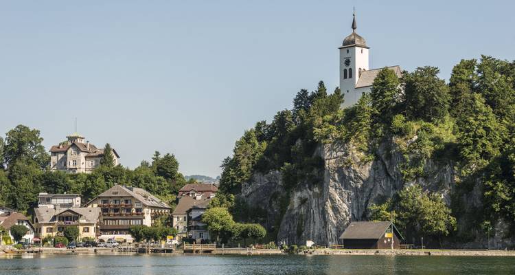 Une église sur un éperon rocheux surplombant un lac.