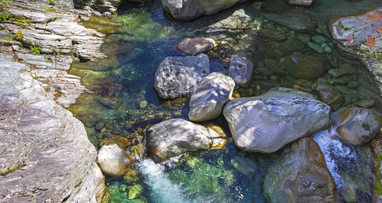 Vue rapprochée d'un ruisseau avec de l'eau claire et des roches lisses.