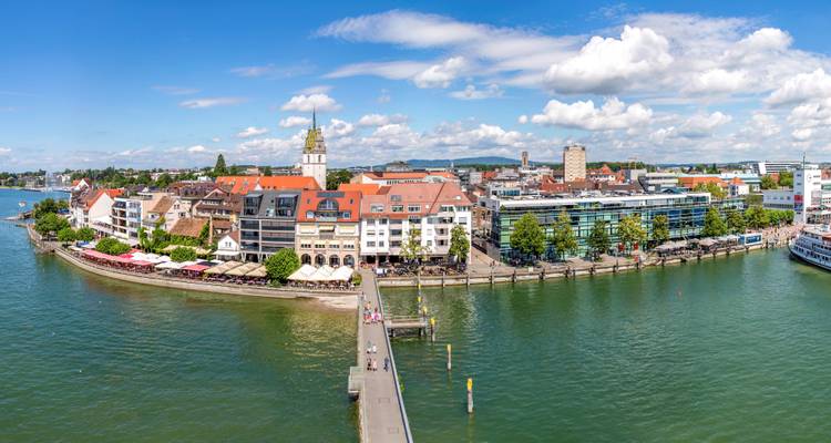 Luftaufnahme einer Stadt am Wasser bei klarem Himmel.