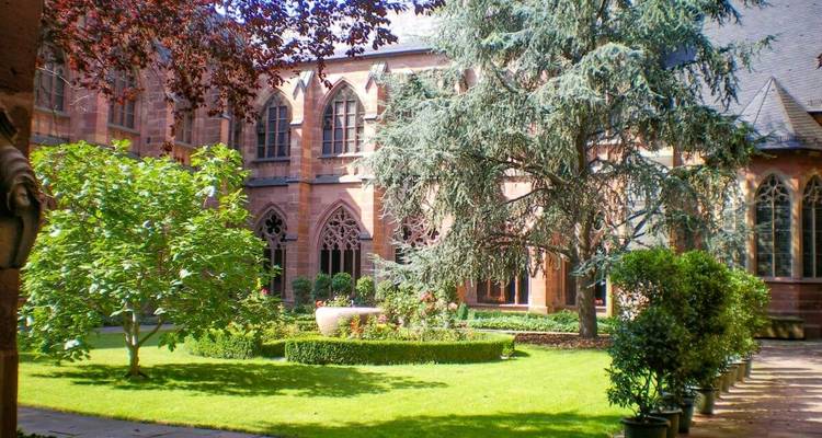 Peaceful garden courtyard surrounded by Gothic architecture.
