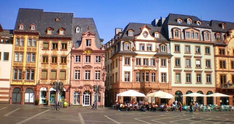 Colorful historic buildings lining a plaza with outdoor seating.