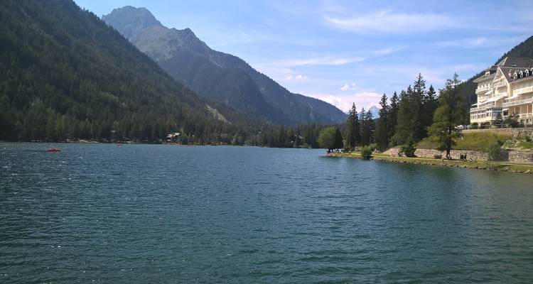 Lake surrounded by mountains and a resort at the lakeside.