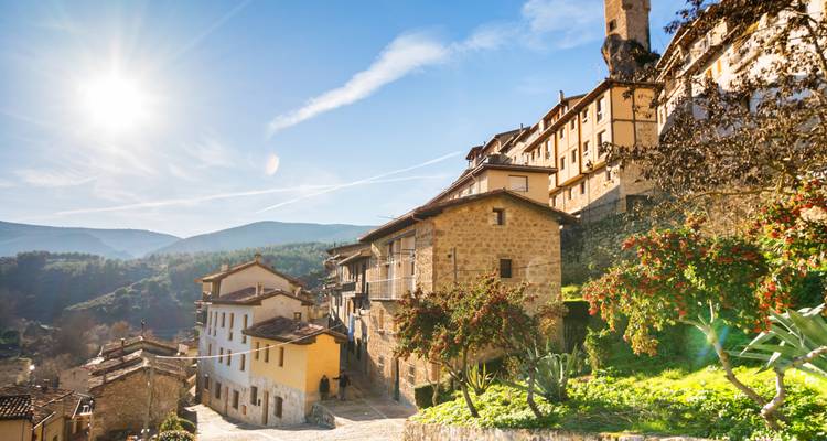 A picturesque village with stone houses under a sunny sky.