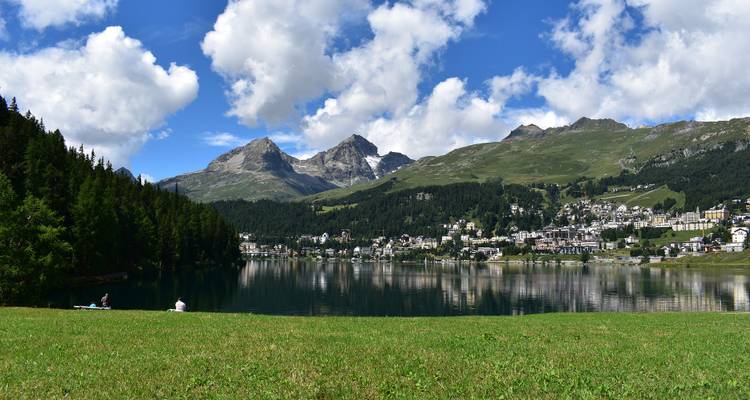 Vue sur le lac avec des montagnes et une ville au loin.