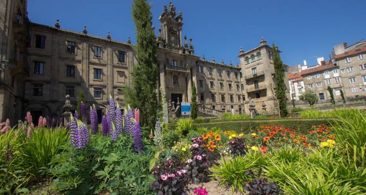 Ein majestätisches Gebäude umgeben von lebendigen Gärten mit Blumen.