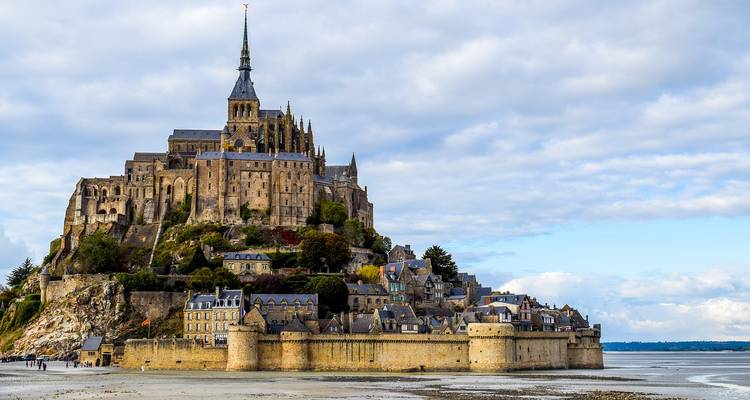 Mont Saint-Michel surrounded by water and sand.