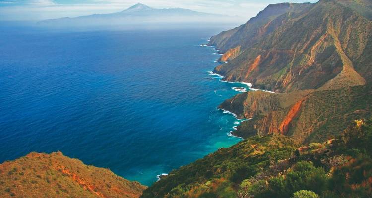 Vue côtière avec des falaises escarpées et un océan bleu vif.
