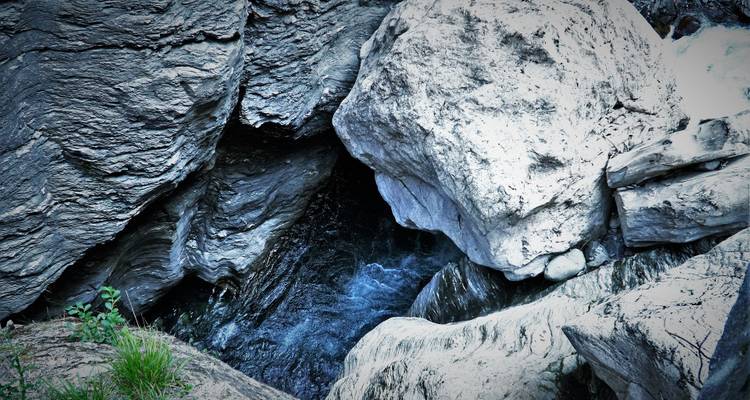 Felsige Gegend mit fließendem Wasser in einer schmalen Schlucht.