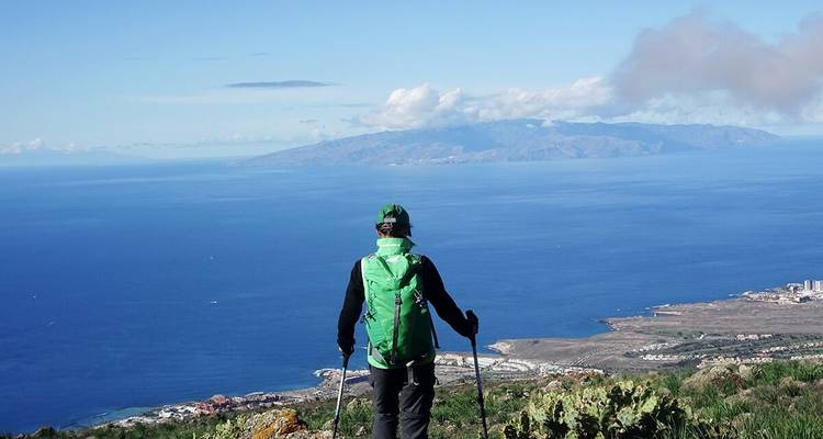 Hiker overlooking the sea and distant islands.