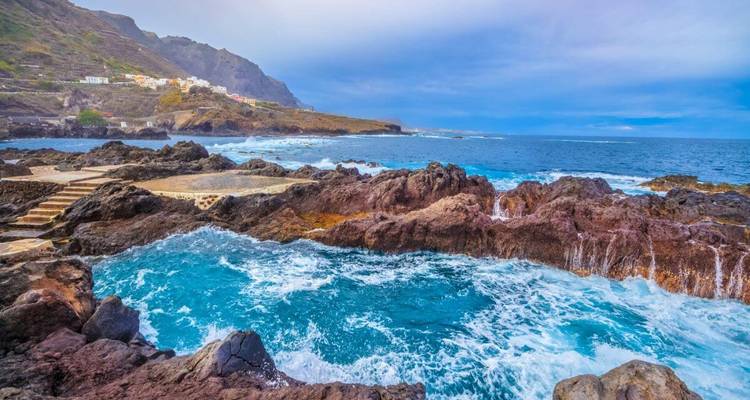 Rocky coastline with buildings in the distance.