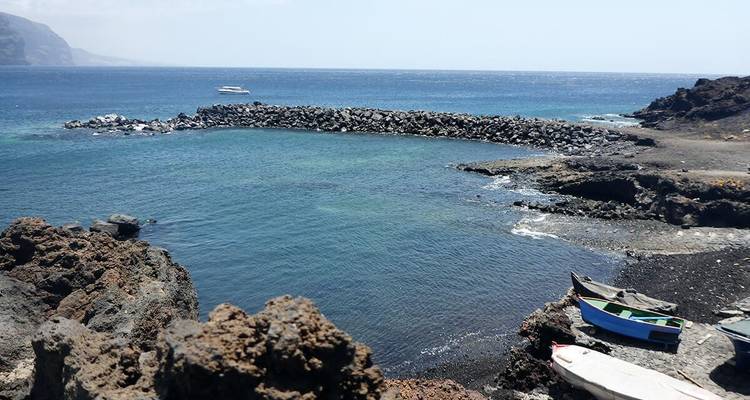 Rocky shoreline with small boats.