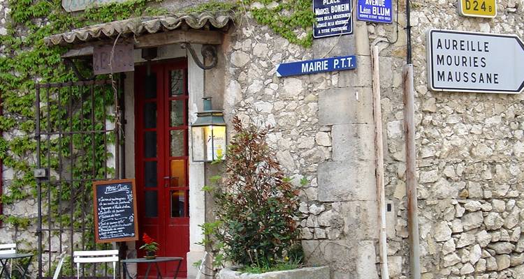 Bâtiment en pierre avec des panneaux indiquant les lieux à proximité.