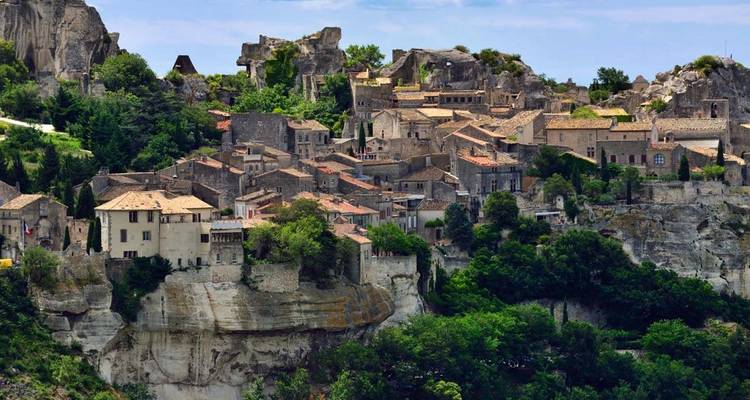 Un village historique construit sur des falaises rocheuses entourées de verdure.
