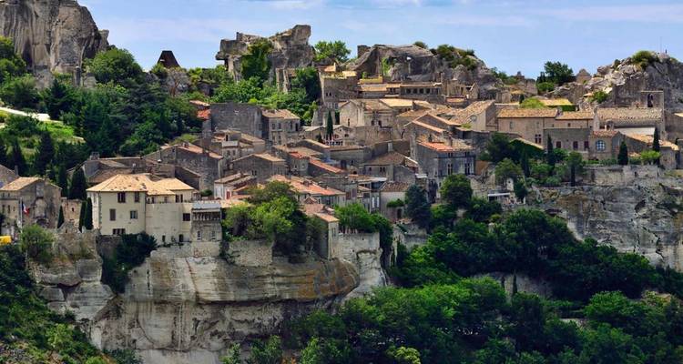 Vue aérienne d'un village historique à flanc de colline avec des bâtiments en pierre.