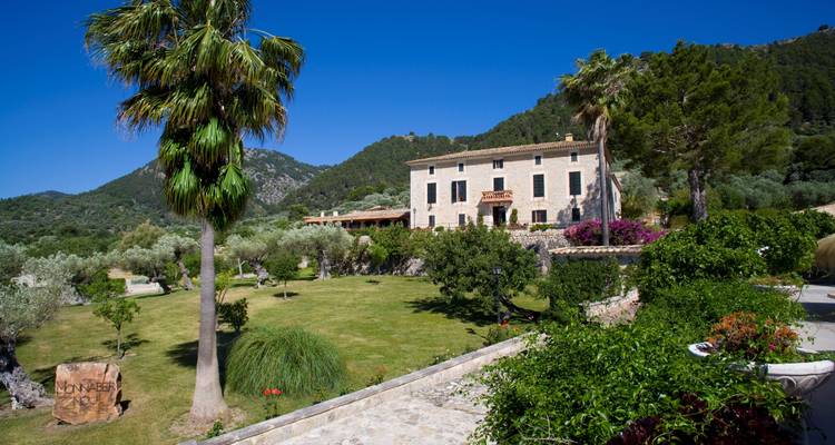 Un bâtiment rustique avec un paysage de palmier et de montagnes.