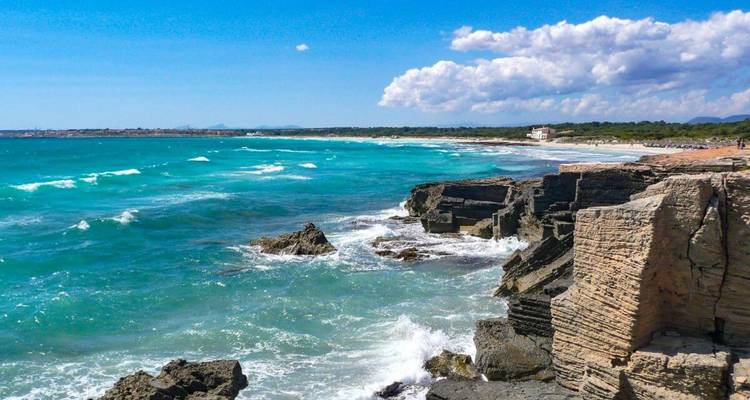 Côte rocheuse avec des vagues turquoise qui se brisent contre les falaises.