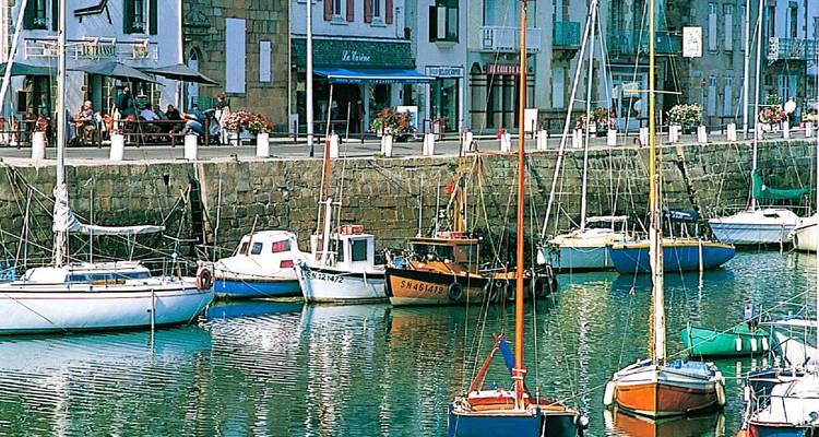 Bateaux amarrés le long d'un canal avec des magasins en arrière-plan.