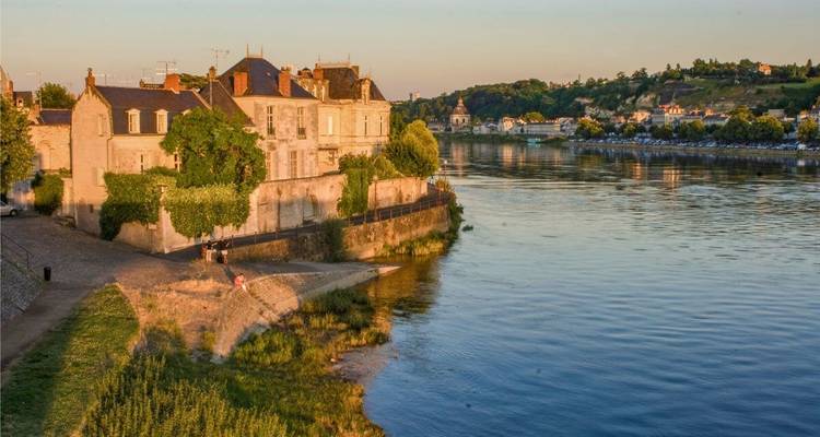 Charmante ville riveraine avec bâtiments historiques au coucher du soleil.