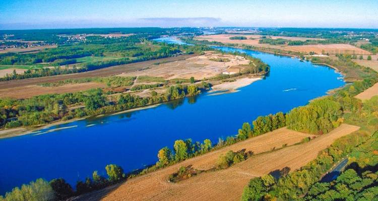 Vue aérienne d'une rivière qui coule à travers des paysages luxuriants.