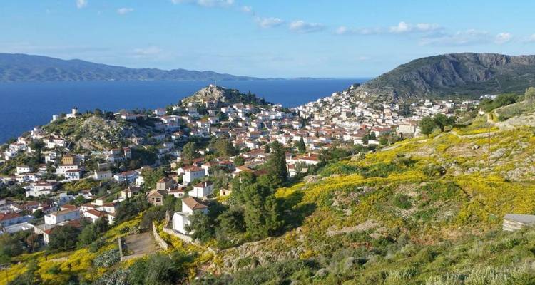 Une vue surélevée d'une ville côtière avec des maisons, la mer et les montagnes.