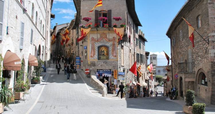 Rue pittoresque avec restaurants et architecture médiévale.