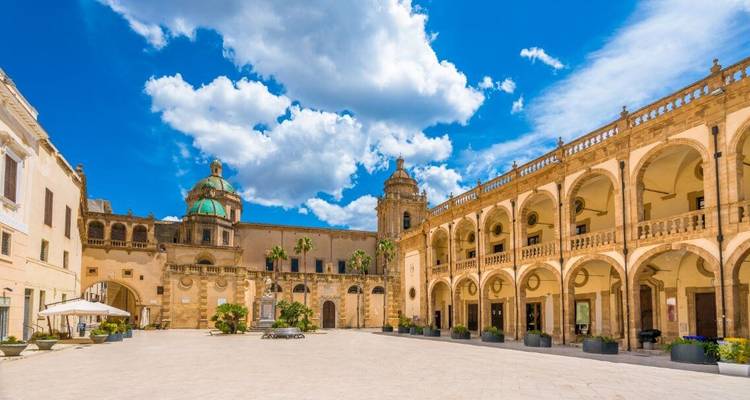Place baroque avec architecture historique sous un ciel lumineux.