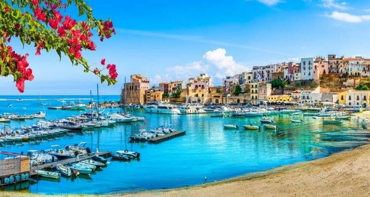 Village côtier coloré avec des bateaux dans un port d'un bleu éclatant.