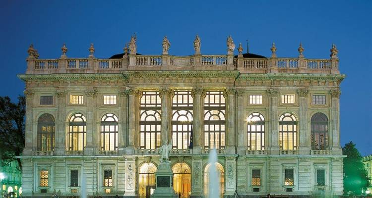 Grand bâtiment historique illuminé la nuit.