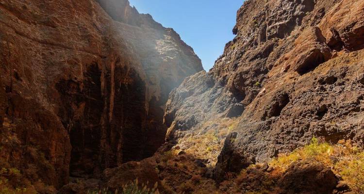 Vue de canyon avec la lumière du soleil filtrant à travers les parois rocheuses.