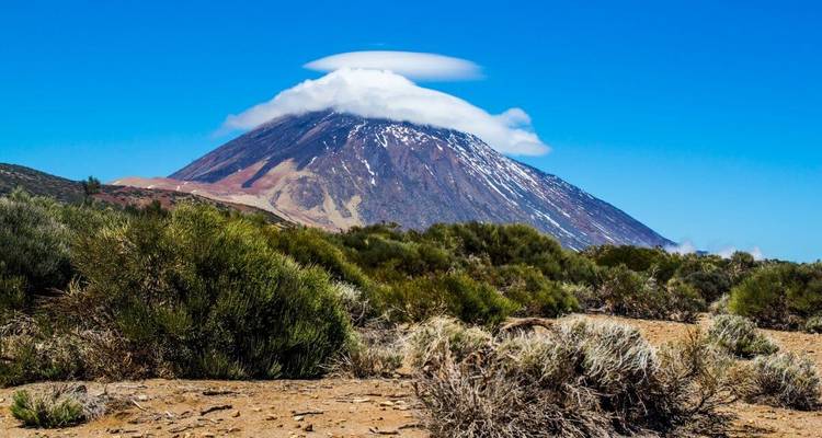 Montagne avec un nuage lenticulaire au sommet contre un ciel vibrant.