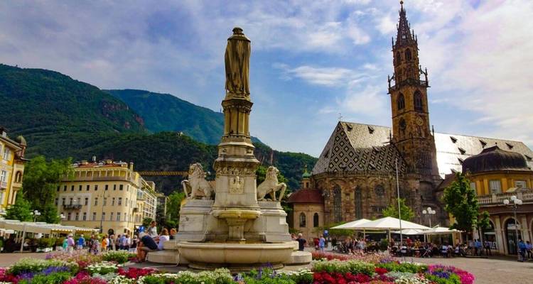Fountain and church with mountains in the background.