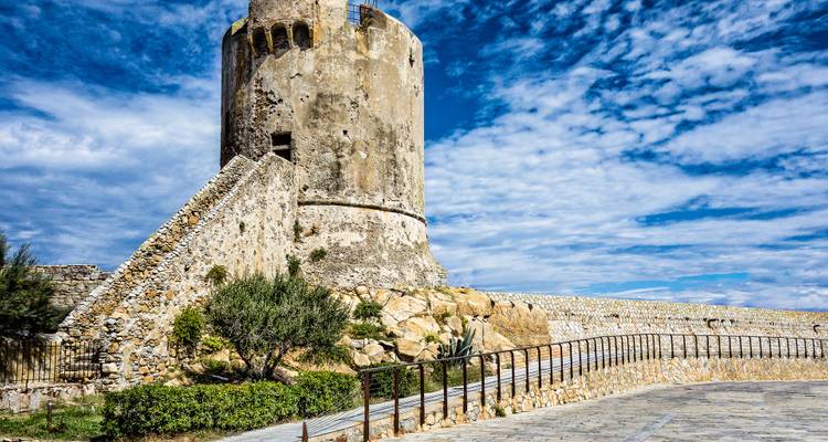 Alter Steinturm mit malerischer Kulisse aus Himmel und Wolken.