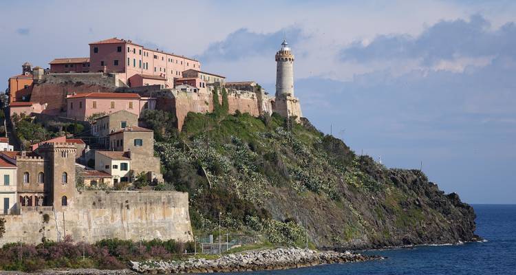 Historische Küstenstadt mit einem Leuchtturm und Klippen.