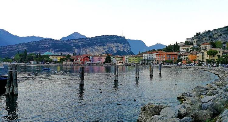 Ville portuaire colorée avec des montagnes en arrière-plan.