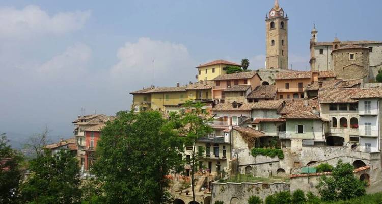 Bergstadt mit Steingebäuden und einem hohen Uhrenturm.