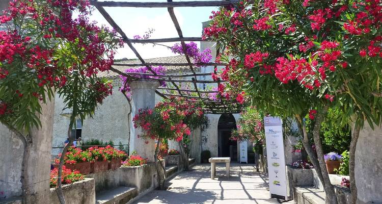 Blumenbedeckter Torbogen, der in ein Gebäude führt.