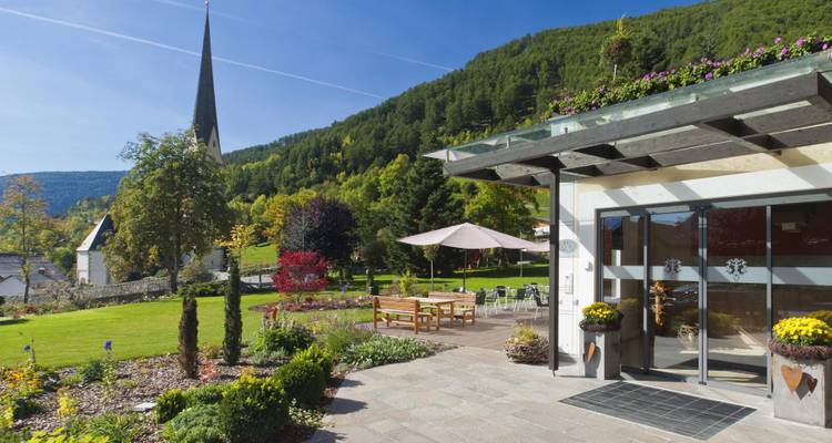 Garden with a modern building and mountain view.