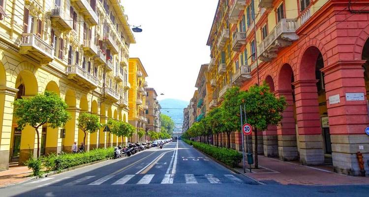Bunte Straße mit großen Gebäuden und Torbögen.