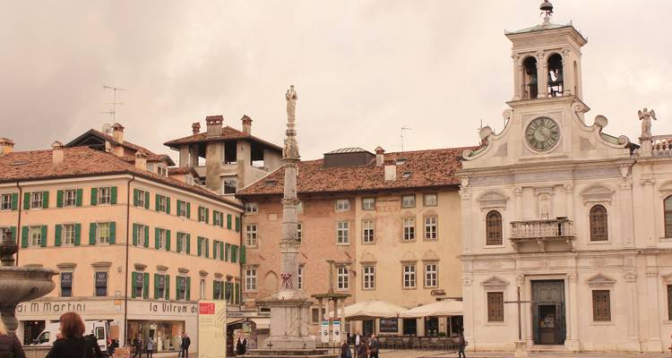 Historisch plein met een klokkentoren en omliggende gebouwen.