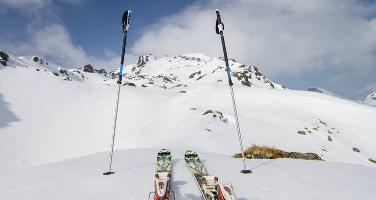 Équipement de ski sur la neige avec des montagnes en arrière-plan.