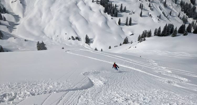 Skieur descendant une pente de montagne couverte de neige.