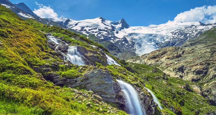 Wasserfälle, die von schneebedeckten Bergen herabstürzen.