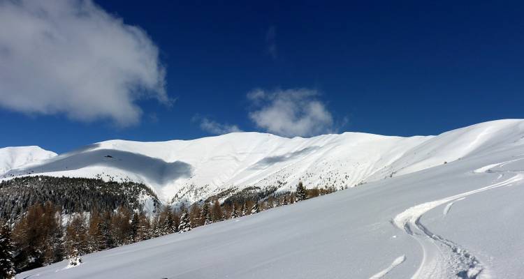 Paysage de montagne enneigé sous un ciel bleu.