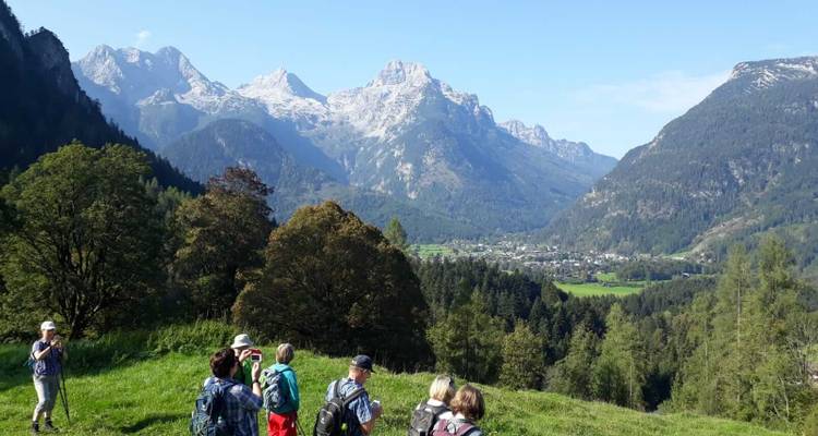 Groupe de randonneurs avec une vue panoramique sur les montagnes et la vallée.