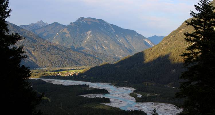 Vallée de montagne pittoresque avec rivière et forêts.