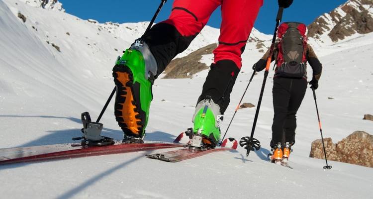 Gros plan sur les chaussures de ski et les skis des skieurs sur la neige, prêts pour une aventure.
