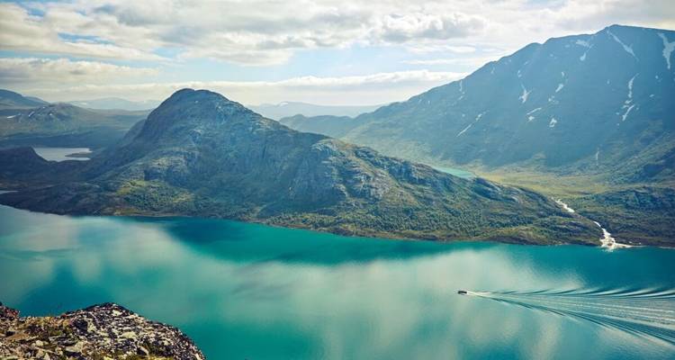 Panoramic view of a mountain range with a turquoise lake.