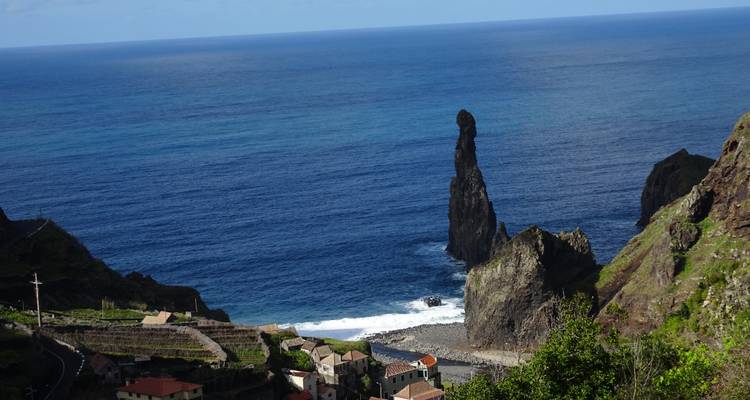 Tall rock formation with rolling ocean waves.