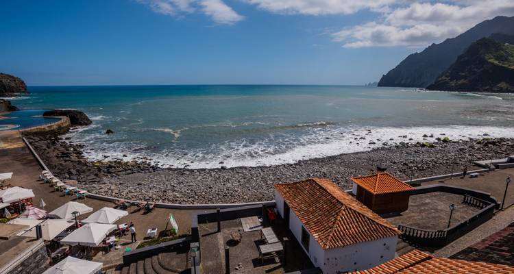 Rocky beach with waves and distant cliffs.