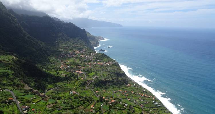 Aerial view of lush green hills and coastline.